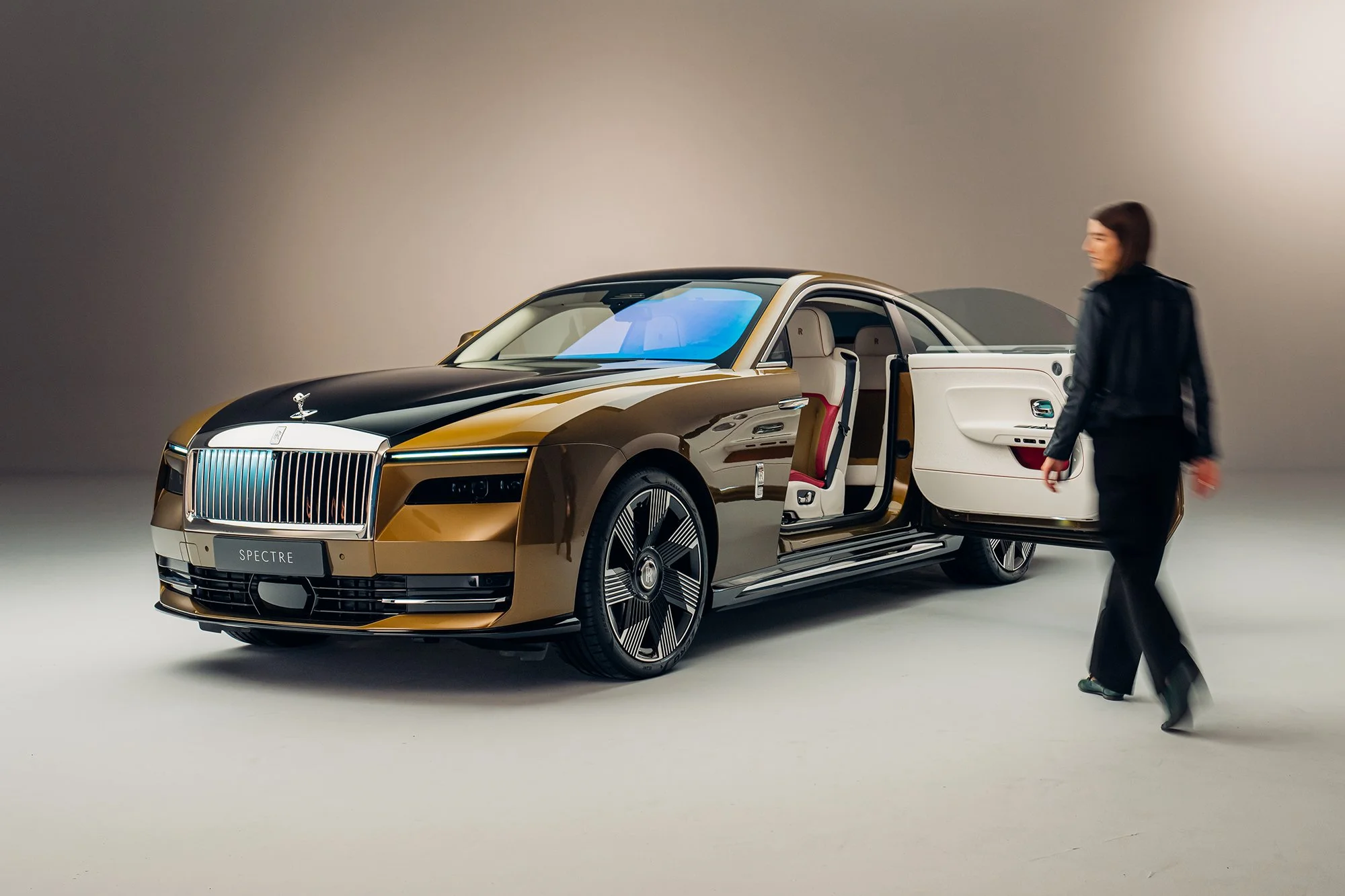 A girl walking towards Rolls Royce Spectre EV