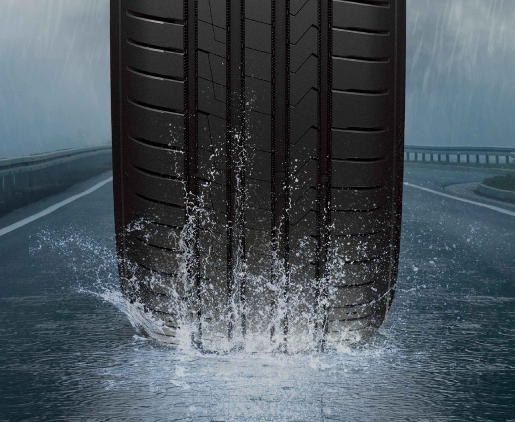 A tyre driving through splashing water.